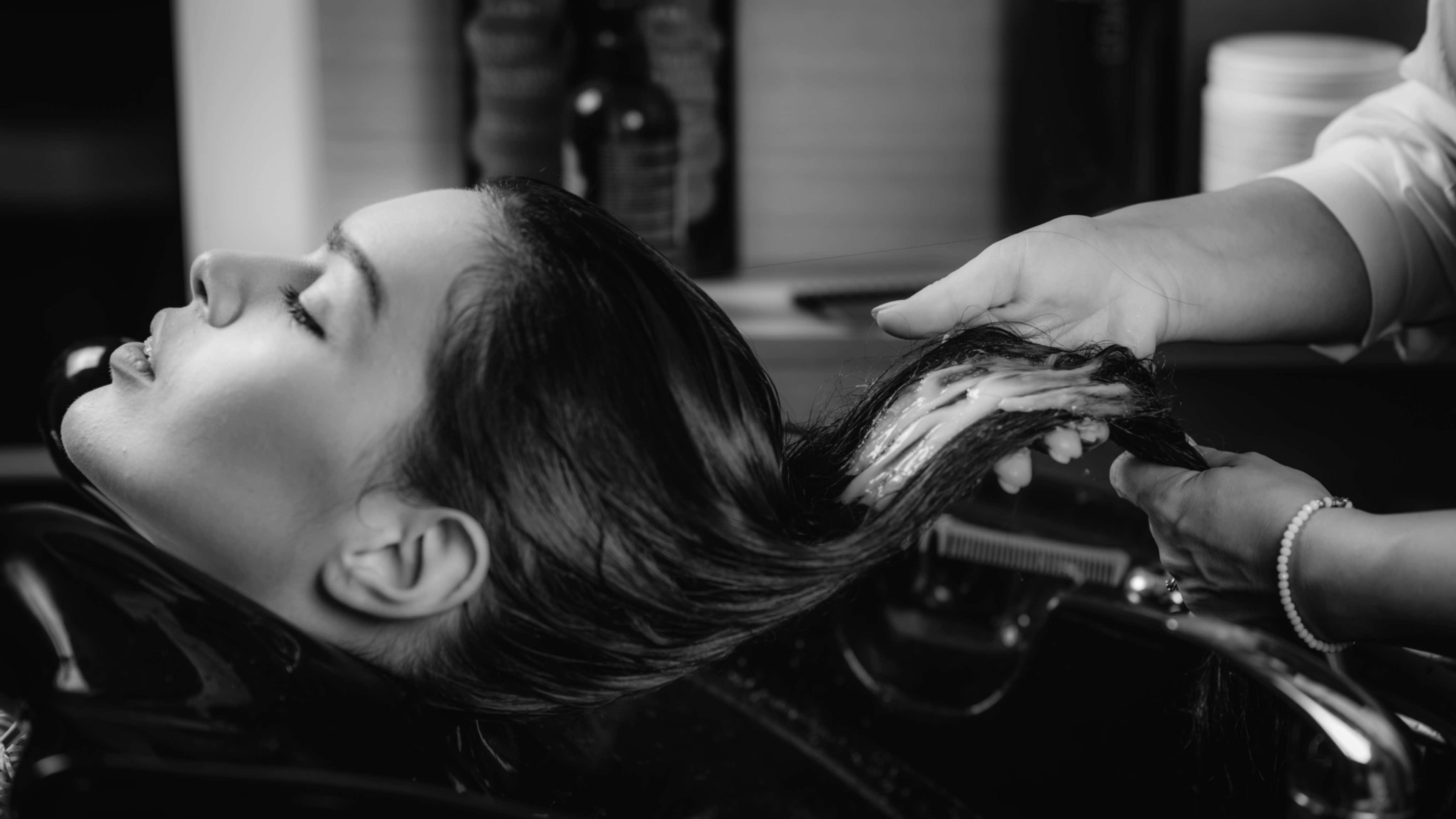Stylist applying a conditioning treatment at the shampoo bowl