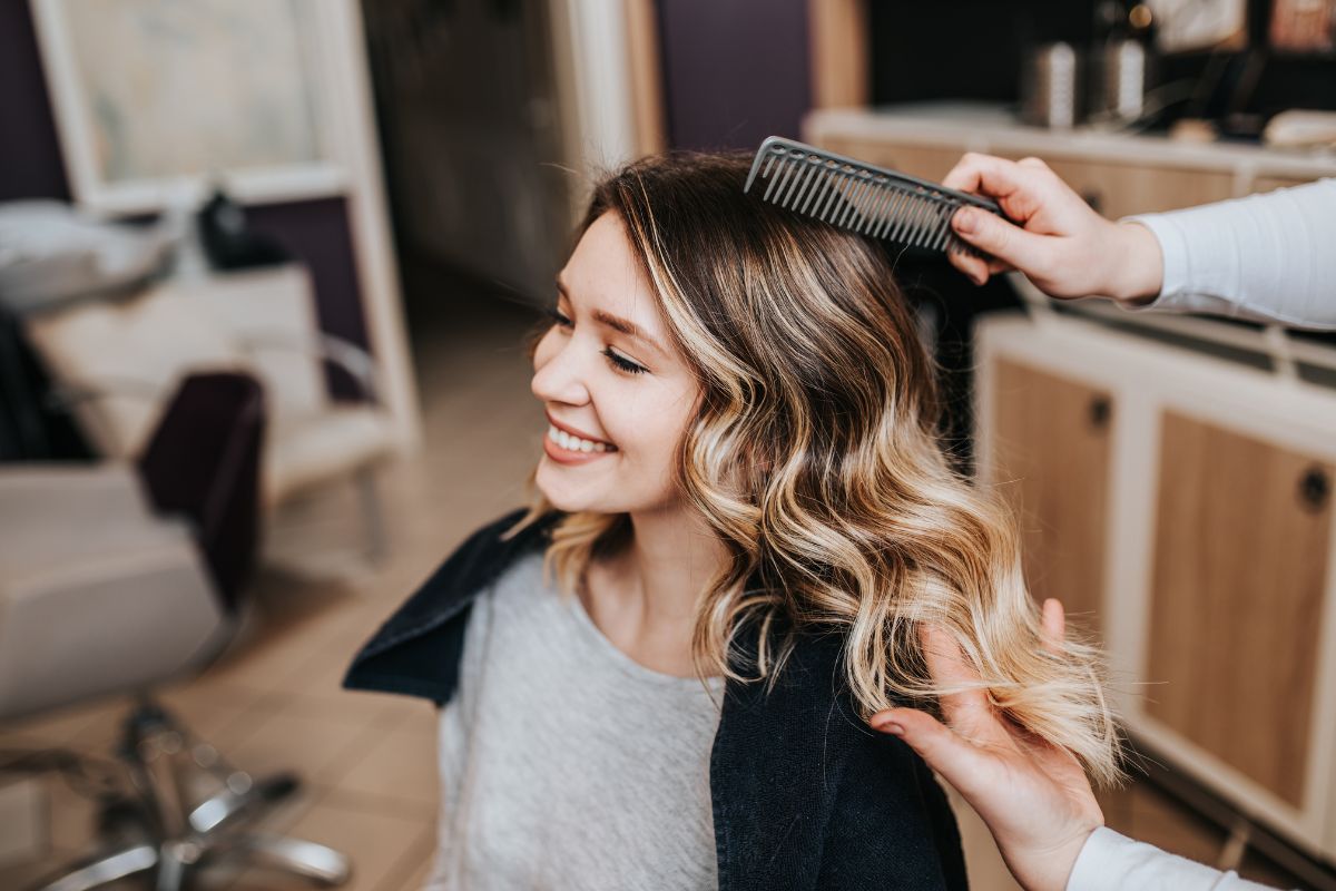 Stylist brushing out a fresh balayage